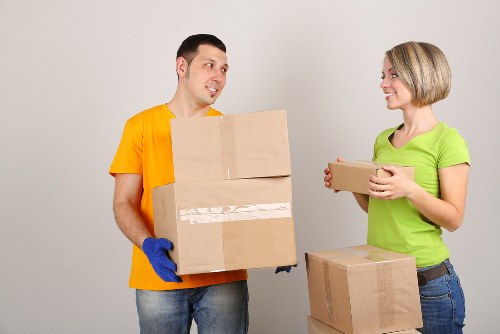 Professional movers carrying a sofa carefully through a home